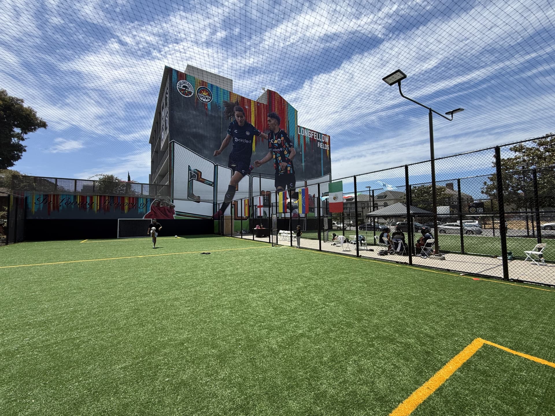 Wide view across the Longfellow Fields turf toward the large soccer mural